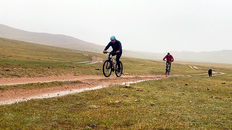 Cycling up to hill against rain